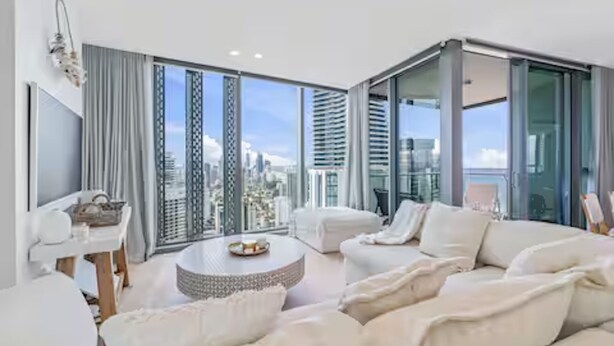 A modern living room with a sofa, a coffee table, and a TV. - Signature 2B2B Stunning Chic Guest Fav +OceanView (Broadbeach)
