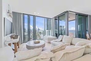 A modern living room with a sofa, a coffee table, and a TV. - Signature 2B2B Stunning Chic Guest Fav +OceanView (Broadbeach)