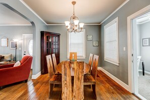 Enjoy meals in this dining room with a wooden table and six chairs, a chandelier, and a sofa.