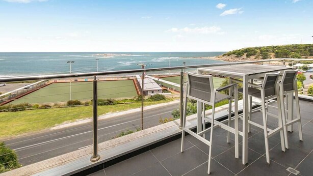 A balcony with a view of the sea and a road. - Strangeways Stays! -Slps 10, 4 Bdrm, Oceanview (Port Elliot)