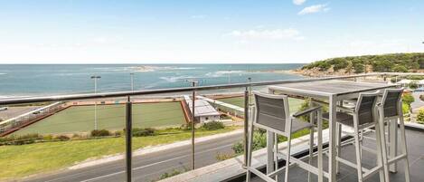 A balcony with a view of the sea and a road.