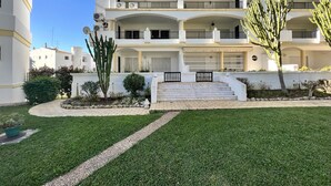 A multi-story building with a central staircase, surrounded by well-maintained lawns and cacti. - VILAMOURA GARDEN VIEW 1 WITH POOL by HOMING (Vilamoura)