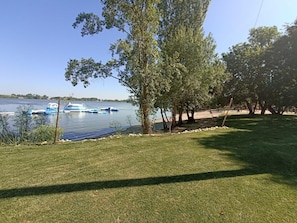 Une zone herbeuse avec un lac et des bateaux.