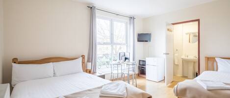 Camera d'albergo con due letti, una scrivania, un televisore e un bagno.