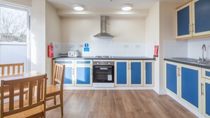 Una cocina con armarios de madera, una estufa y un ventanal.
