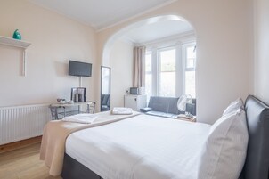 Escritorio, cortinas blackout y tabla de planchar con plancha 