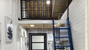 A compact kitchen with a blue ladder, a white brick wall, and a wooden ceiling. - The Birds Nest in Central Phoenix (Phoenix)