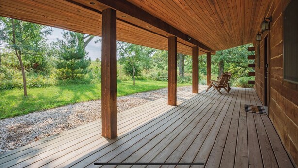 Une terrasse en bois offrant une vue sur un paysage verdoyant.