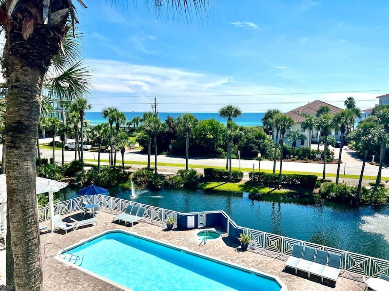 A swimming pool with lounge chairs and a view of the ocean.