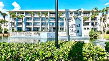 A hotel named Gulf Place Cabanas with a pool and palm trees in the foreground.