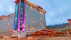 A large hotel with a modern design, featuring a prominent tower and multiple floors.