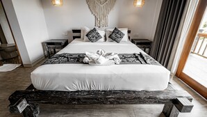 A neatly made bed with a white and black patterned bedspread, two bedside tables, and a macrame wall hanging. - Tropical Garden Villa with Beautiful View In Ubud (Ubud)