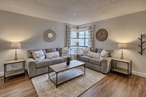 Relax in this inviting living room with a large coffee table, two sofas, and a lamp.