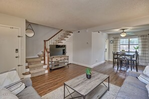 Relax in this inviting living area with a flat-screen TV, dining table, and comfortable seating.