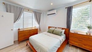 A bedroom with a bed, wooden dresser, and a window with curtains. - Beautiful Gem In The Heart of Condado - 3 mins from the beach! (San Juan)