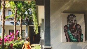 A modern building with a tropical garden, a mural, and a statue. - LONG TERM Rent Only - Budget Friendly Private Room (Ubud)