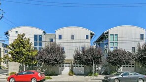 Stunning residential building with a symmetrical facade surrounded by a lush lawn and mature trees.