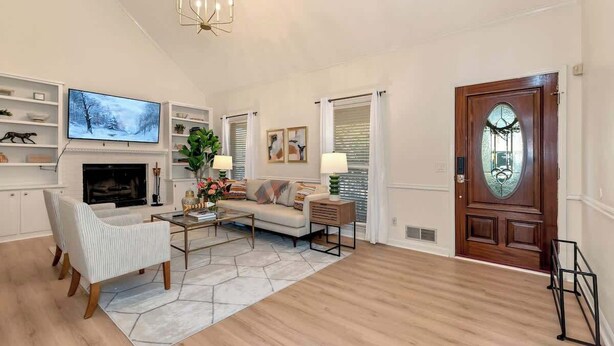 A living room with a fireplace, a television, a sofa, and a coffee table. - Pool House/ 9beds/4Ba/ Kings/ Billiard/ Air Hockey (Lawrenceville)