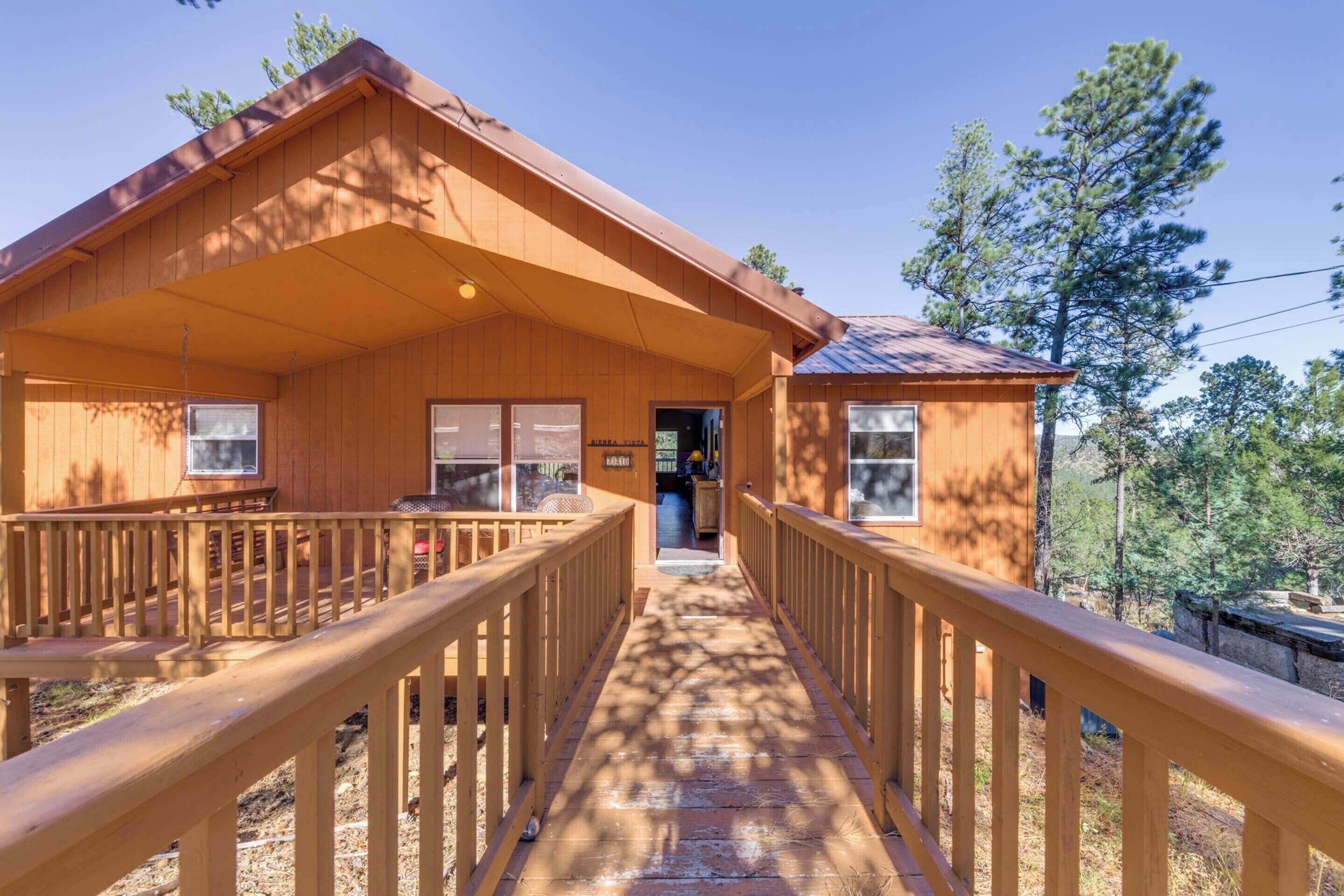 Eine Holzhütte mit überdachter Veranda und einer Terrasse.