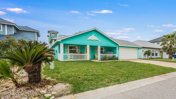 A turquoise house with a white porch and a garage. - Diving Dolphin by Silver Sands Vacation Rentals (Port Aransas)