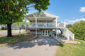 A two-story house with a covered porch and a staircase leading to the upper level.