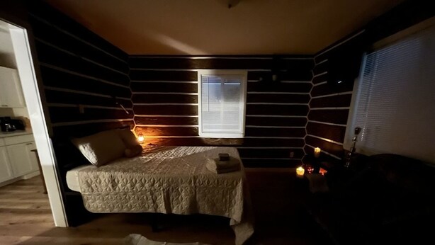 A cozy bedroom with a bed, a small table, and a window. - Scout- a rustic “cabin” apartment, very fast wifi (Salem)