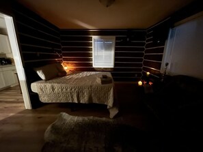A cozy bedroom with a bed, a small table, and a window. - Scout- a rustic “cabin” apartment, very fast wifi (Salem)