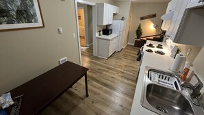 A compact kitchen with a wooden bench, a sink, and a stove. - Scout- a rustic “cabin” apartment, very fast wifi (Salem)