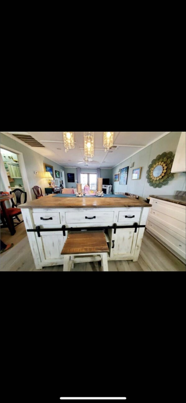 A kitchen with a central island, white cabinetry, and pendant lighting.