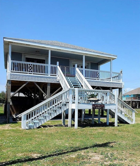 A two-story building with a central staircase leading to a balcony.
