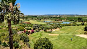 A golf course with multiple holes, water bodies, and surrounding greenery. - São Rafael Beach House (Albufeira)