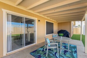 Relax in the covered patio area with a barbecue grill and comfortable seating for four.