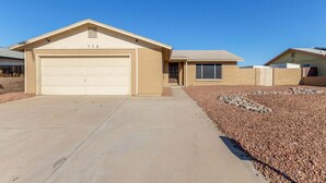 A residential house with a garage, a front door, and a driveway leading to the garage.