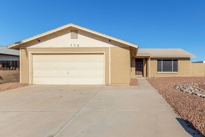A single-story house with a garage, a small porch, and a clear sky.