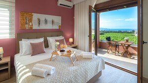 A hotel room with a large bed, a breakfast tray, a table with chairs, and a view of the landscape. - Cretan Vineyard Hill Villa 2 | Private pool, panoramic view, beautiful vineyard (Άνω Καλεσια)