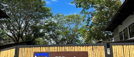 A bamboo fence with a sign that reads "Blue Window."