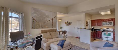 A spacious living area with a glass desk, a sofa, and a dining table.