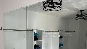 Un baño moderno con un espejo grande, suelo de mármol y una ducha a ras de suelo.