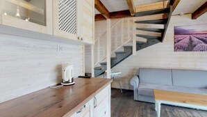 A wooden interior with a kitchen counter, a white kettle, a gray sofa, and a staircase. - Stunning home in Karwia with heated swimming pool (Karwia)