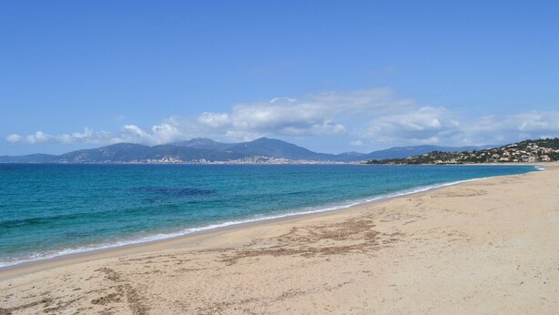 A beach with clear blue water, a sandy shore, and distant mountains. - 2 bedroom lovely home in Grosseto-Pugna (Grosseto-Pugna)