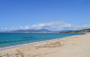 A beach with clear blue water, a sandy shore, and distant mountains. - 2 bedroom lovely home in Grosseto-Pugna (Grosseto-Pugna)
