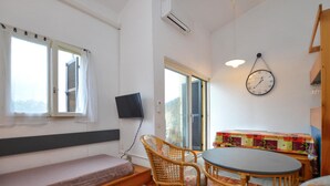 A room with a bed, a table with chairs, a wall clock, and a television. - 2 bedroom lovely home in Grosseto-Pugna (Grosseto-Pugna)