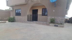 A building with a flat roof, a balcony with a black railing, and a satellite dish on the side. - Have a Quality time with your Family in this  3bed apartment on the ground floor (Lagos)