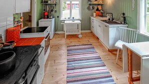 A kitchen with wooden flooring, a striped rug, and a window with a view of the outside. - Awesome home in Boxholm with WiFi (Boxholm)
