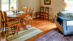 A cozy living room with a round wooden table, four chairs, a blue sofa, and a patterned rug. - Awesome home in Boxholm with WiFi (Boxholm)