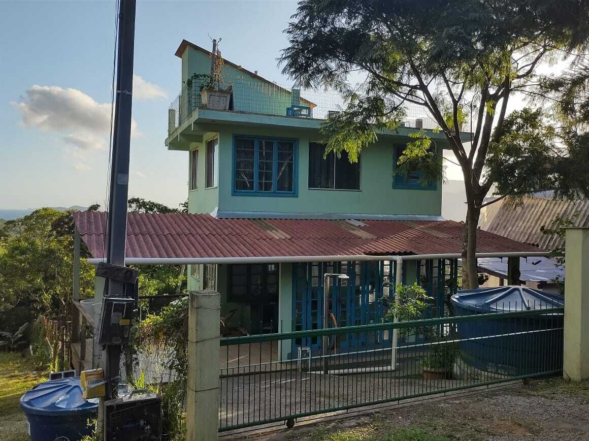 A two-story building with a green exterior and a red roof.