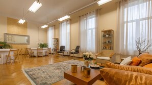 A spacious living room with a wooden coffee table, a sofa, and a dining area with chairs and a table.