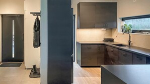 Une cuisine moderne avec des meubles de couleur sombre, un plan de travail et une fenêtre donnant sur un beau paysage.