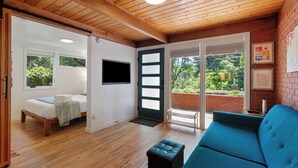Een kamer met een bed, een blauwe bank en een houten plafond.