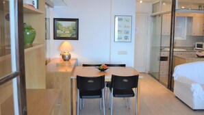A modern hotel room with a dining area, a bed, and a kitchenette. - Apartament Bloc Goya (Begur)
